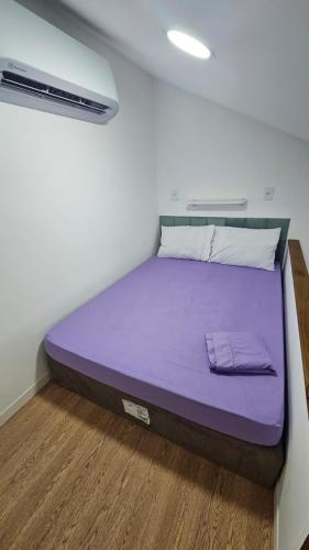 a bed in a room with a purple mattress at Pousada Bahamas Sc in Penha
