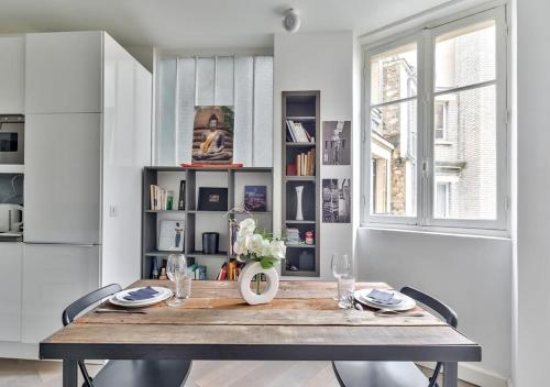 une salle à manger avec une table et une fenêtre dans l'établissement Bright & Modern Flat in le Marais - An Ecoloflat, à Paris