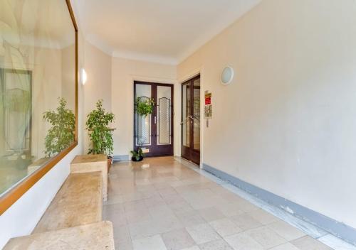 un couloir vide avec une porte et des plantes en pot dans l'établissement Bright & Modern Flat in le Marais - An Ecoloflat, à Paris