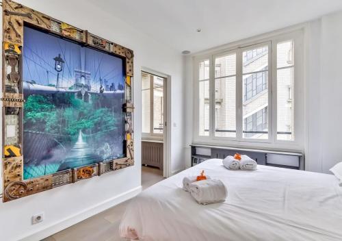 - une chambre avec une grande télévision murale dans l'établissement Bright & Modern Flat in le Marais - An Ecoloflat, à Paris