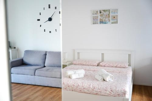 2 imágenes de un dormitorio con cama y reloj en Prestige apartment, en Lugano