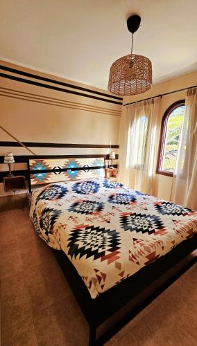 a bedroom with a bed with a colorful comforter at Blue Oasis in Corralejo