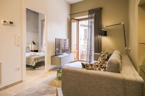 a living room with a couch and a bedroom at Can Bona Casa - Apartamento con vistas a la plaza in Besalú