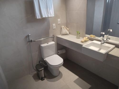 a bathroom with a white toilet and a sink at HCM - Hotel Corais de Manaira in João Pessoa