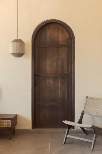 a wooden door in a room with a bench at Rawstone Luxury Villas Jaipur in Jaipur