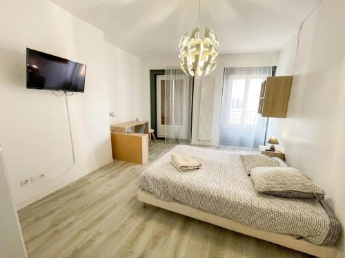 une chambre avec un lit et un lustre dans l'établissement Le Stéphanois cozy centre-ville spacieux, à Saint-Étienne