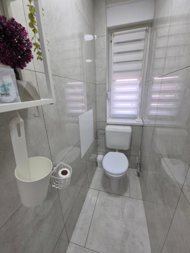 a white bathroom with a toilet and a sink at Gajeva Rooms - Toronto apartment SELF CHECK-IN in Virovitica