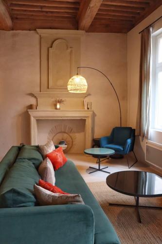 - un salon avec un canapé vert et une chaise dans l'établissement Appartement de Caractère avec Cachet Unique à Uzès, à Uzès