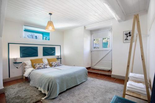 a bedroom with a bed and two windows at Casa das Camélias Tortas in Castanheira de Pêra