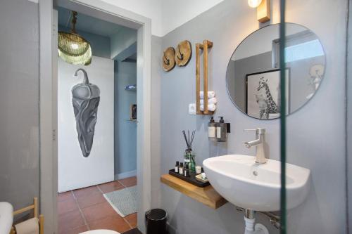 a bathroom with a sink and a mirror at Casa das Camélias Tortas in Castanheira de Pêra