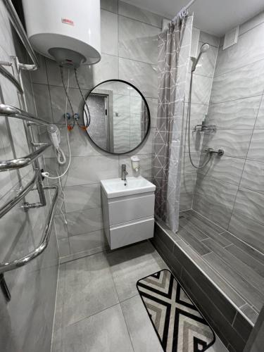 a bathroom with a sink and a shower and a mirror at Avto Spa in Khmelʼnytsʼkyy