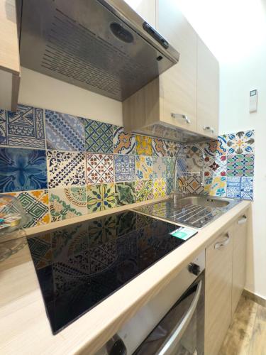 a kitchen with colorful tiles on the wall at My Life in Palermo