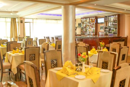 貢德爾的住宿－AG Hotel Gondar，用餐室配有桌椅和黄色弓