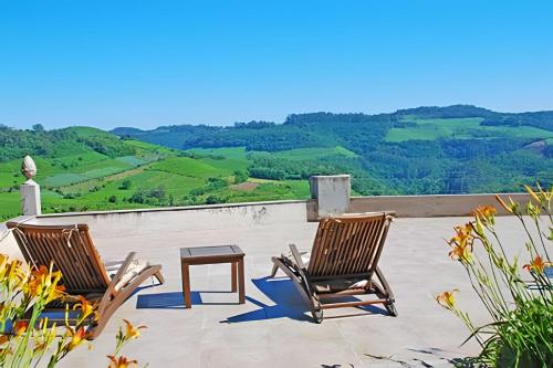 two chairs and a table on a patio with a view at Pousada Borghetto – Charme e Exclusividade no Vale dos Vinhedos in Bento Gonçalves