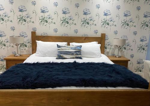 un letto con una coperta nera sopra con due lampade di La Montgrande Bed & Breakfast ad Aulnay