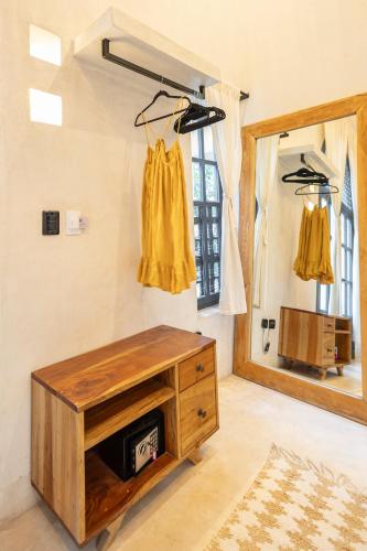 a room with a wooden dresser and a mirror at Yum Kaax Boutique Villa in Tulum