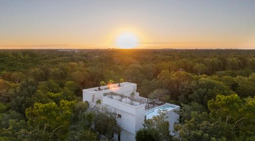 an aerial view of a house with the sunset in the background at Yum Kaax Boutique Villa in Tulum