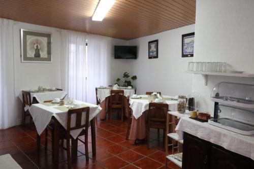 a restaurant with tables and chairs in a room at Residencial Miguel José in Estremoz