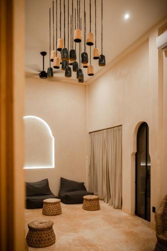 a living room with a couch and a chandelier at Yum Kaax Boutique Villa in Tulum