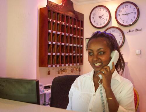 a woman talking on a phone in a room with clocks at AG Hotel Gondar in Gonder