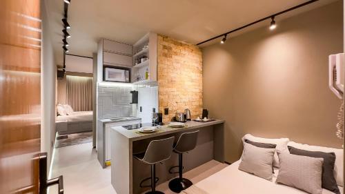 Kleines Zimmer mit einem Schreibtisch und einem Schlafzimmer. in der Unterkunft Studio de Luxo Urban in Brasilia