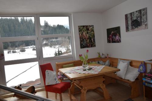 ein Esszimmer mit einem Tisch und einem großen Fenster in der Unterkunft Ferienwohnungen Ellmer in Flachau