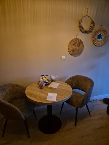 a wooden table with two chairs and a table with at Vallei - appartement de Es in Rolde