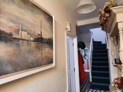 a painting hanging on a wall next to a staircase at City centre room Ensuite in Cork