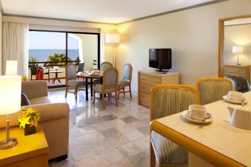 a living room with a table and chairs and a television at Samba Vallarta All Inclusive in Nuevo Vallarta 