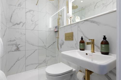 a white bathroom with a sink and a toilet at The Broughton Townhouse in Edinburgh