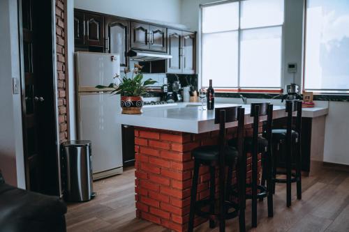 a kitchen with a brick island in the middle at Casa FRANLUS Apartmento 3 Planta alta in San Cristóbal de Las Casas