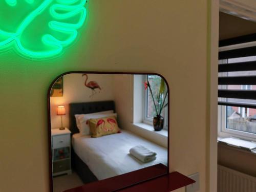 a mirror reflecting a bedroom with a bed and a pink flamingo at Dakota 2Bed - AwayOnBusiness in Eastleigh