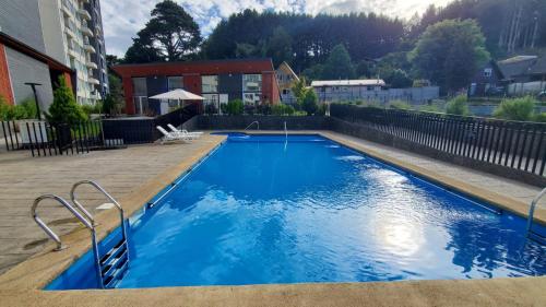 Departamento Mirador al Volcan في فيلاريكا: حمام سباحة بمياه زرقاء أمام مبنى