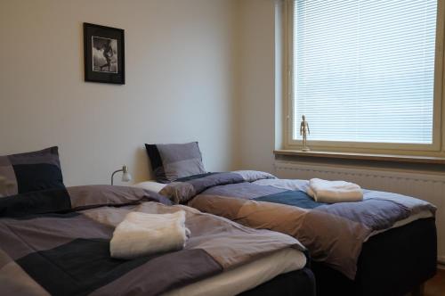 two beds sitting next to each other in a bedroom at A two-bedroom with river view in Kajaani