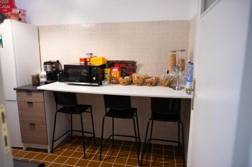 een keuken met een aanrecht met krukken en een magnetron bij Dimora Mafalda B&B in LʼAquila