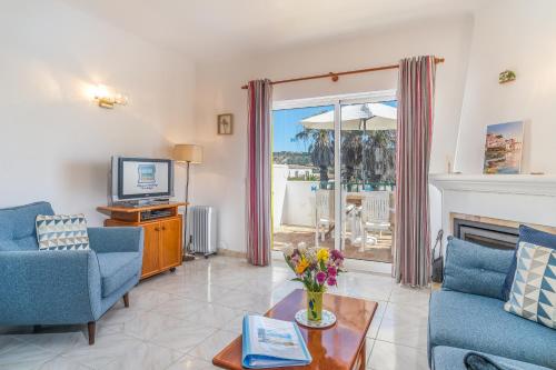 a living room with a fireplace and a tv at Casa Azure in Luz