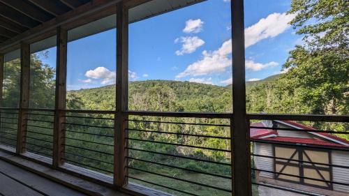 a view from the window of a cabin with mountains in the background at Red Roof mountain cabin with Starlink internet! in Pine Grove