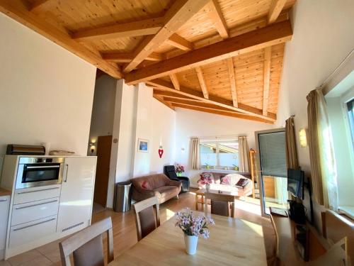 a kitchen and living room with wooden ceilings and a table at Haus Christine in Neukirchen am Großvenediger