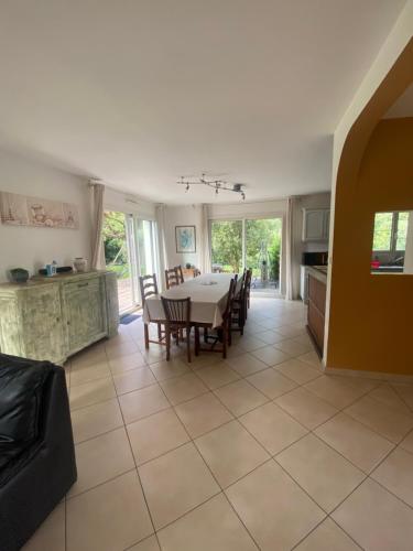 une cuisine et une salle à manger avec une table et des chaises dans l'établissement Maison de charme proche océan, à Lauzach