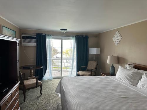 a hotel room with a bed and a window at Sands Of Time Motor Inn & Harbor House in Woods Hole