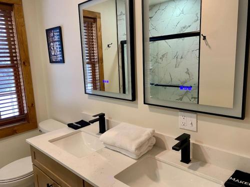 Un baño con lavabo, inodoro y espejo. en Luxury 2 Bedroom Suite 202B, en Wilmington
