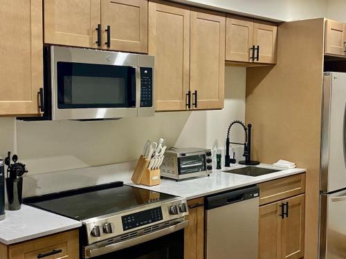 a kitchen with stainless steel appliances and wooden cabinets at Luxury ADA Unit - 101 in Wilmington