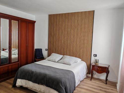 a bedroom with a bed and a wooden wall at Casa Rosales in La Orotava