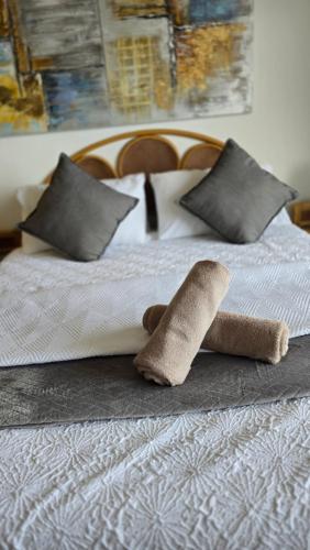 a bed with two rolled up towels on it at 407 L'Escalier Cabanas -Beachfront Paradise in Amanzimtoti