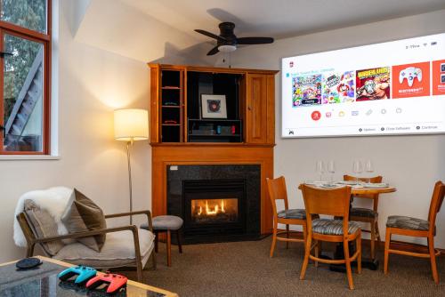 a living room with a fireplace and a tv at Village Penthouse w Views Pool and Hot Tub in Whistler