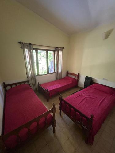 a room with two beds and a window at La Luisa in Merlo