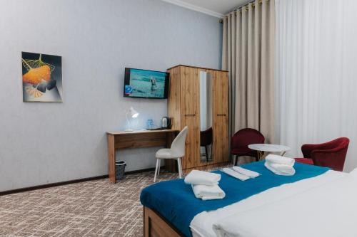 a hotel room with a bed and a desk at Resident Hotel in Tashkent