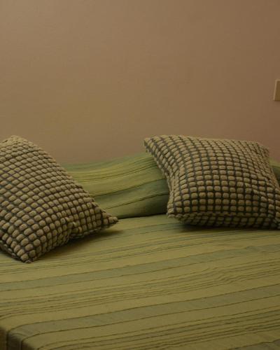 a bed with two pillows on top of it at La Casina Punta Ala in Punta Ala