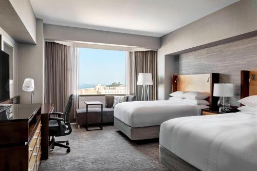 a hotel room with two beds and a desk at San Francisco Marriott Union Square in San Francisco