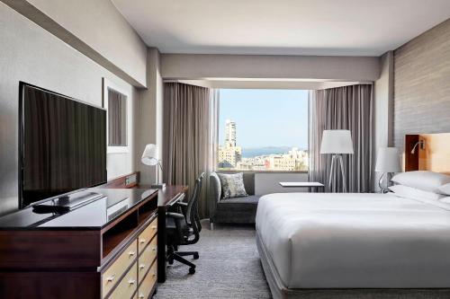 a hotel room with a bed and a desk and a television at San Francisco Marriott Union Square in San Francisco